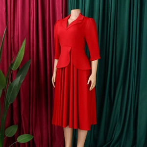 Détail de robe rouge avec col tailleur, taille à basque et jupe midi plissée