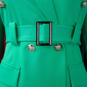 Detail of green blazer dress featuring golden lion head buttons and black waist belt buckle