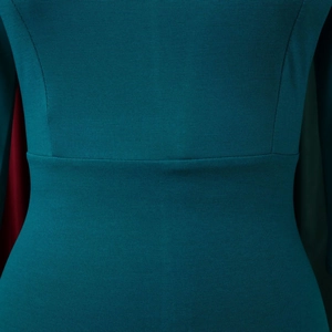 Detail of teal knit dress showing waist stitching and textured fabric quality