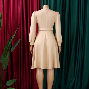 Dettaglio del retro di un abito a linea A beige a maniche lunghe con cerniera invisibile