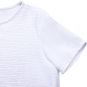 Gros plan du haut blanc à col rond montrant la texture gaufrée du tissu et les coutures