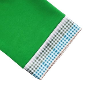 Close-up of bright green knit top sleeve with blue and white checkered trim detail