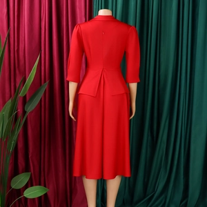 Vue arrière d'une robe trapèze rouge élégante avec fermeture éclair et ourlet évasé