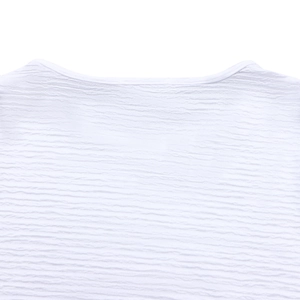 Gros plan détaillé du tissu texturé à vagues blanches sur l'encolure d'un haut femme