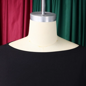 Primo piano dell'elegante scollo rotondo e del tessuto plissettato di un abito nero