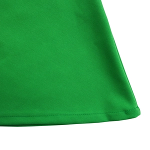 Close-up of professional double-stitched hem on a bright green African fashion dress
