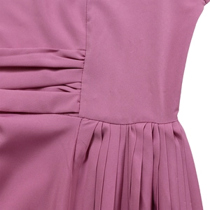 Detailed macro view of pleated fabric texture and side gathering on mauve dress