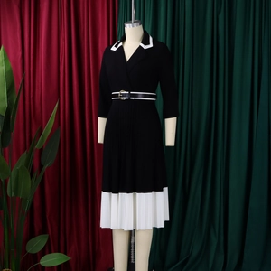 Detail of the white contrast collar and pleated hemline on the black knit dress