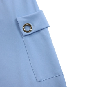 Détail du tissu bleu clair avec poche à rabat rectangulaire et œillet métallique brillant