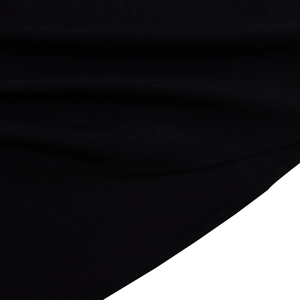 Macro shot of black knitted cotton fabric showing soft texture and draped folds