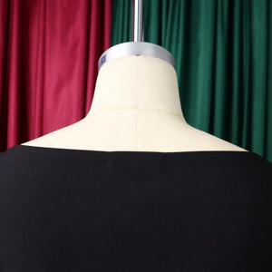 Dettaglio dell'elegante scollo rotondo nero con tessuto plissettato e maniche a tre quarti