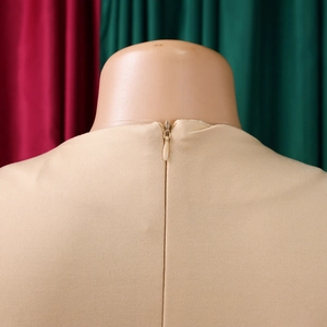 Dettaglio ravvicinato della cerniera invisibile posteriore di un abito elegante beige a trapezio