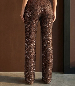 Dettaglio posteriore di pantaloni in paillettes bronzo scintillanti per feste eleganti