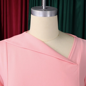 Detail of light pink dress with elegant asymmetrical crossover neckline and layered design