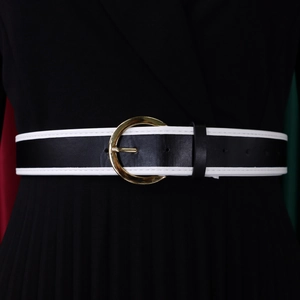 Detail of a black leather belt with white contrast edges and a gold round metal buckle
