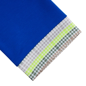 Close-up of royal blue fabric stitched with colorful plaid patterns on elegant dress sleeve