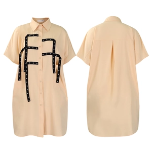 Detail of light orange midi shirt dress with metallic rivets and classic lapel collar