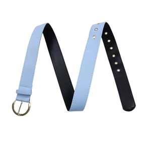 Détail de la ceinture bleu clair avec boucle dorée ronde et œillets métalliques