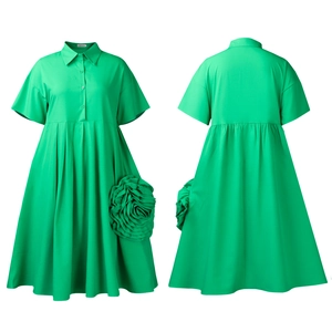 Detail of green shirt dress featuring short sleeves and a large 3D floral decoration
