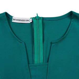 Gros plan du décolleté d'une robe vert foncé avec fermeture éclair invisible et étiquette