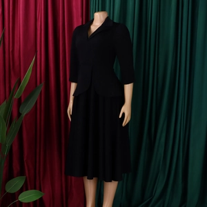 Détail du col de style vintage et des manches 3/4 ajustées sur une robe noire élégante
