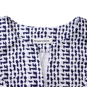 Détail du col en V avec étiquette taille S sur une robe à imprimé géométrique bleu