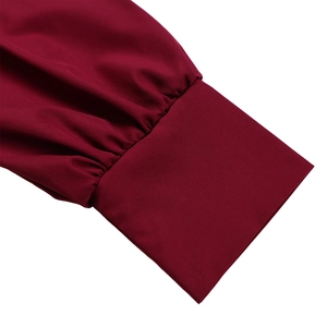 Close-up of elegant wine red lantern sleeve cuffs with pleated details on the dress