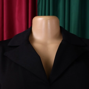 Gros plan d'un revers de veste de costume noire à manches trois-quarts en tissu lisse