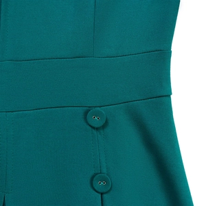 Gros plan détaillé d'une robe en maille vert foncé avec taille cintrée et boutons
