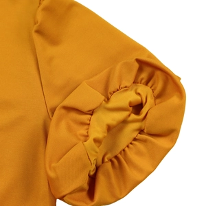 Detailed view of ginger yellow puff sleeve with elastic pleated cuff and fabric texture