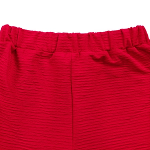 Détail de la texture plissée rouge et de la taille élastique d'un ensemble décontracté