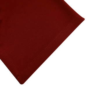 Dettaglio del tessuto a maglia rosso scuro con cuciture a doppio ago e trama del materiale