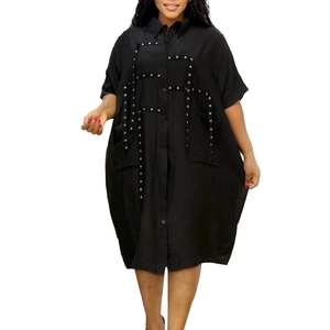 Detail of black oversize shirt dress with silver studs and front button closure
