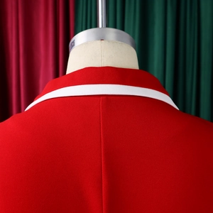 Close-up detail of the red blazer neckline with contrasting white decorative trim