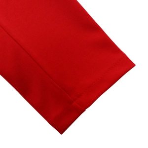 Detailed close-up of the red knitted dress sleeve featuring precise double-needle stitching