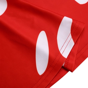 Vue détaillée du tissu à pois rouges et blancs avec une finition soignée à double couture