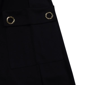 Détail de la poche de robe noire taille haute avec boucles métalliques dorées