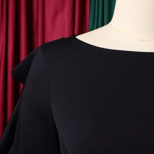 Detailansicht des eleganten schwarzen schulterfreien Oberteils mit Volantschulter