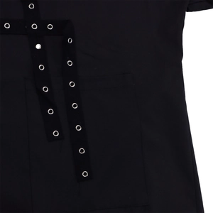 Close-up of black shirt detail featuring silver metal eyelets on fabric ribbons and pocket
