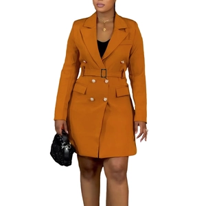 Detail of a mustard yellow double-breasted blazer dress with classic lapels and metal buttons