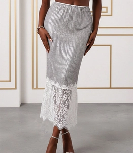 Detailed view of silver sequin skirt featuring delicate white floral lace patchwork hem