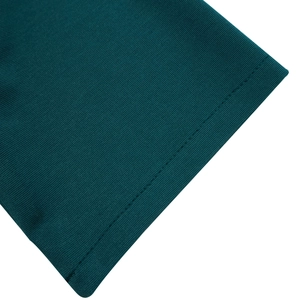 Dettaglio del tessuto a maglia verde scuro con cuciture piatte e trama fine del vestito