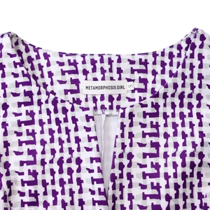 Détail du col rond avec fente en V sur la robe à imprimé géométrique violet et gris