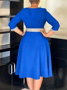 Elegant royal blue midi dress with checkered belt and sleeve cuffs in a back view