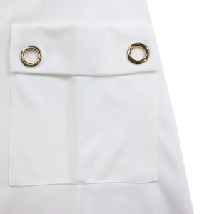 Détail d'une poche de robe blanche avec œillets dorés et coutures de haute qualité