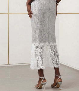 Detail of silver sequin midi skirt with elegant white floral lace hem and slim fit