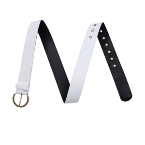 Détail d'une ceinture en cuir PU blanc avec boucle dorée ronde et œillets