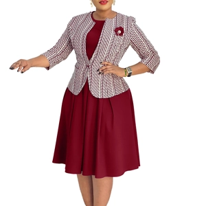Détail de la robe bordeaux avec veste en tweed, broche fleurie et texture de maille unique
