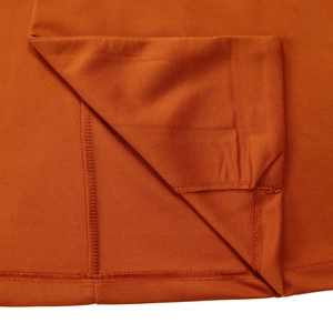Detailed close-up of double-stitched hem and premium orange cotton fabric texture
