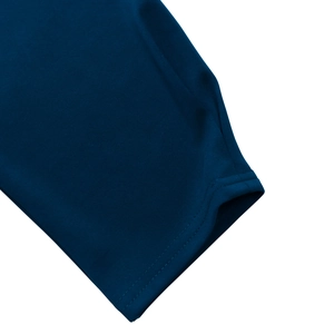Vue macro de la texture du tissu en maille bleu foncé et coutures de précision du poignet
